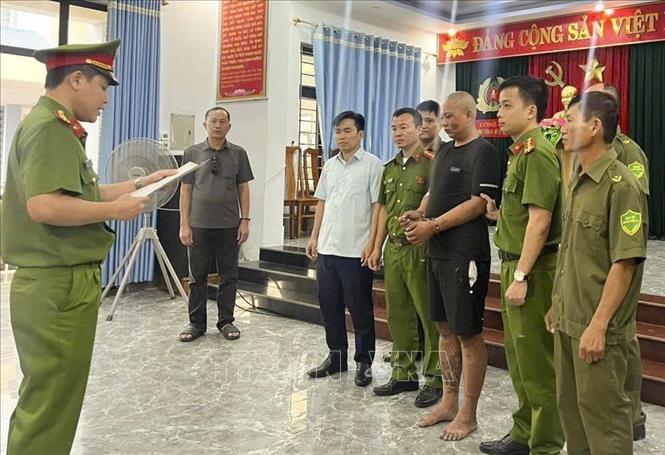 Tống đạt quyết định giữ người trong trường hợp khẩn cấp đối với Nguyễn Viết Hoàng để điều tra về hành vi giết người. Ảnh: TTXVN phát